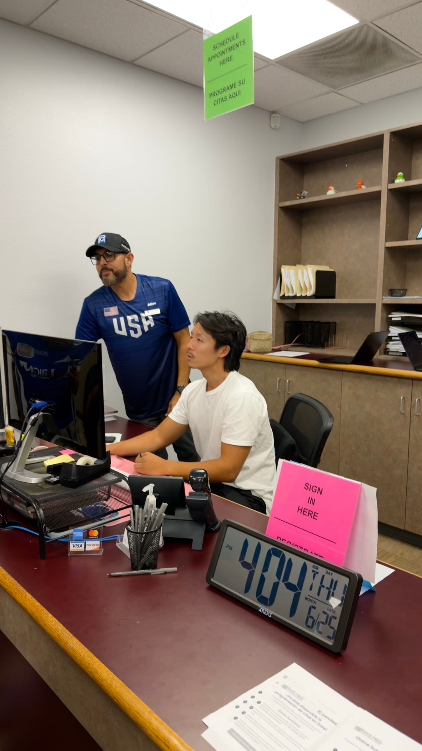 Pedro Santana with Penciled's Justin at the Phys Med front desk during on-site setup