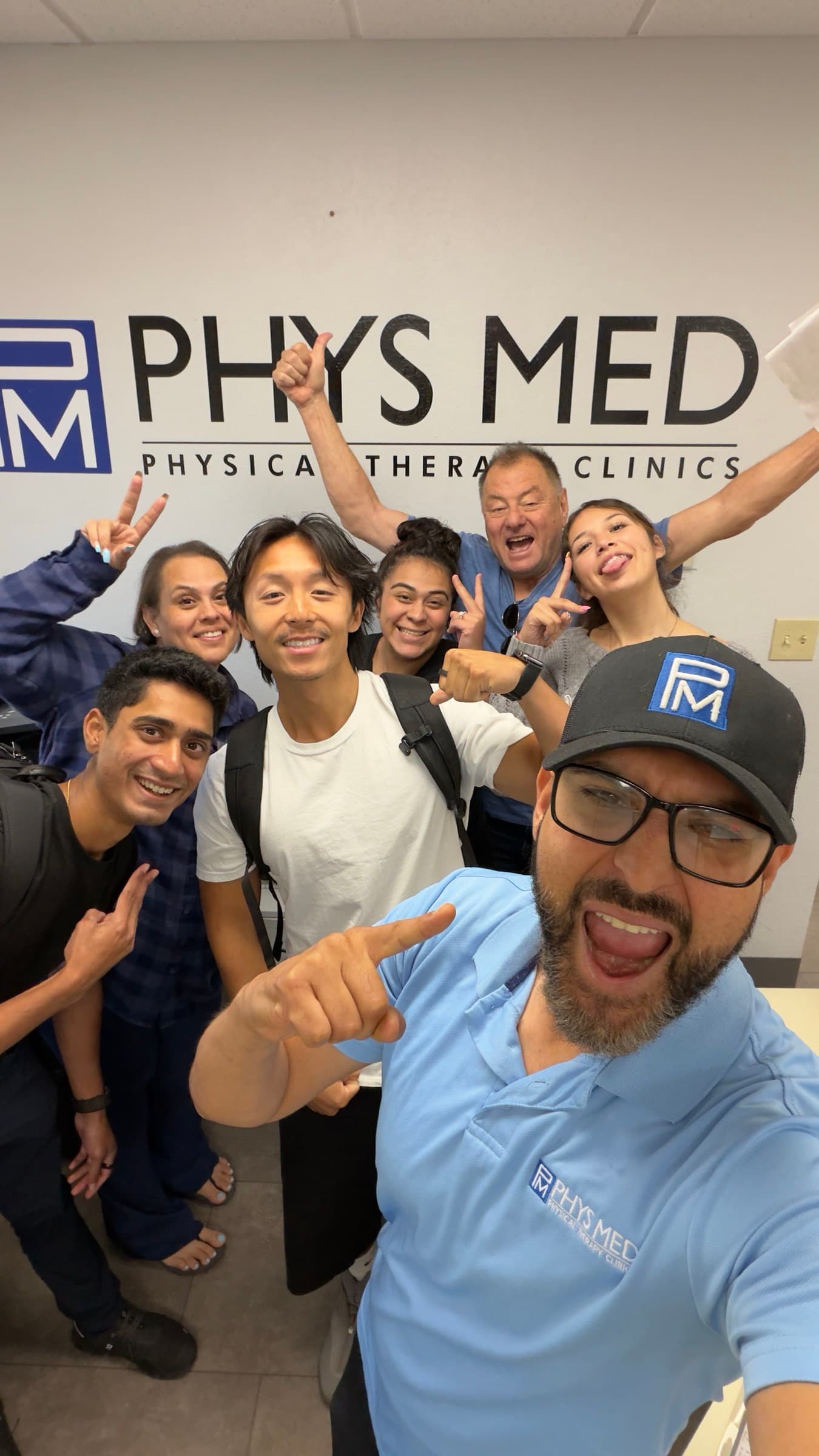 The Phys Med team with Penciled's Shawn and Justin under the clinic's sign